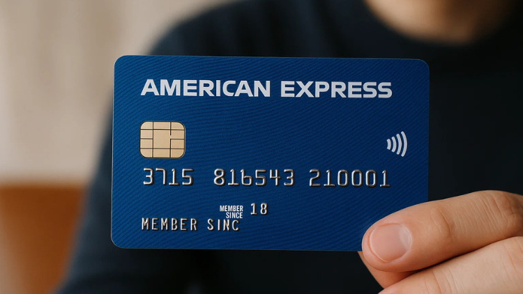 A hand holds a blue American Express credit card with a contactless payment logo.