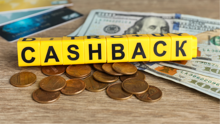 Yellow blocks spelling cashback are displayed on top of coins and dollar bills.