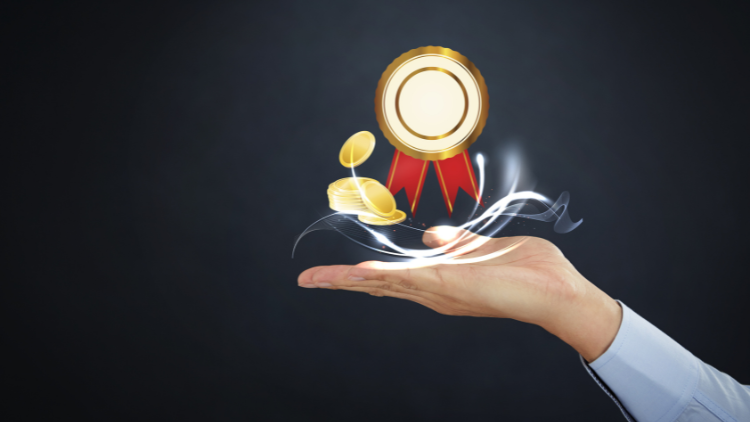 Businessman’s hand presenting floating golden coins and a medal, representing earning rewards.
