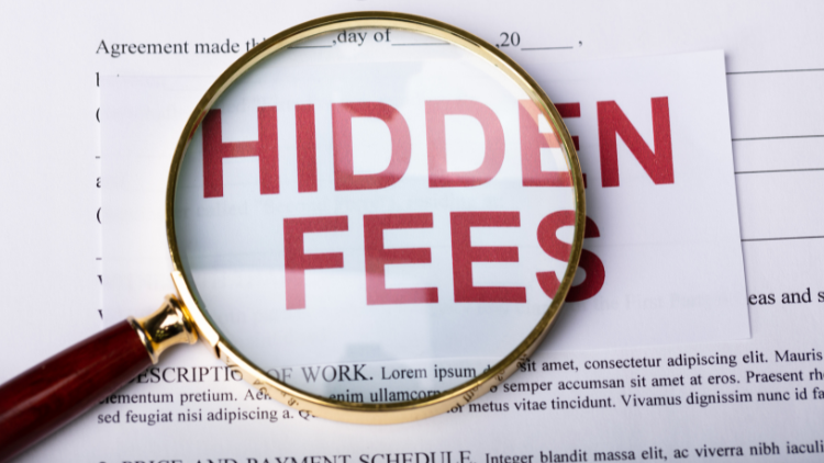 A magnifying glass highlighting the words “Hidden Fees” on a financial document.
