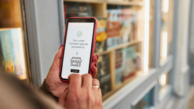A person holds a smartphone displaying a message confirming their order was placed successfully.