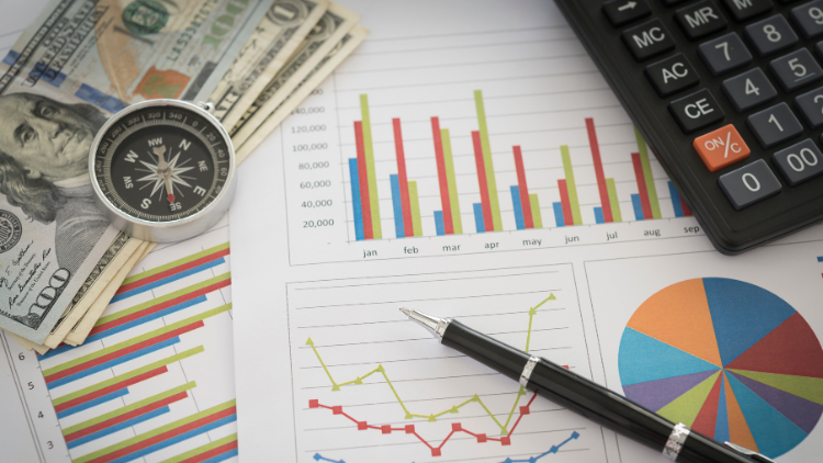 Financial charts with cash, pen, calculator, and compass, representing referral bonuses tied to financial growth.