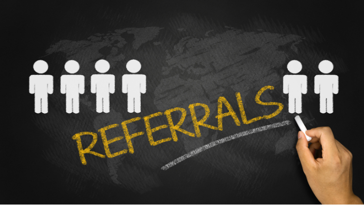 Word “Referrals” written on chalkboard with stick figures, representing earning points through referral programs.