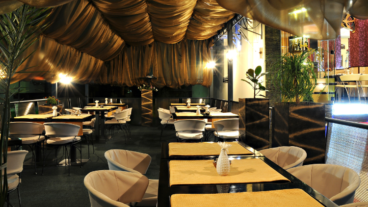 Elegant restaurant interior with empty tables set for dinner, highlighting opportunities to earn rewards while dining out.