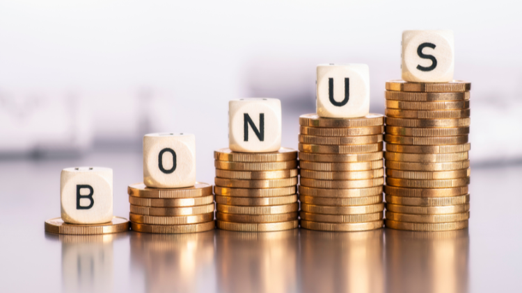 Stacks of gold coins with dice spelling the word bonus to represent financial rewards.
